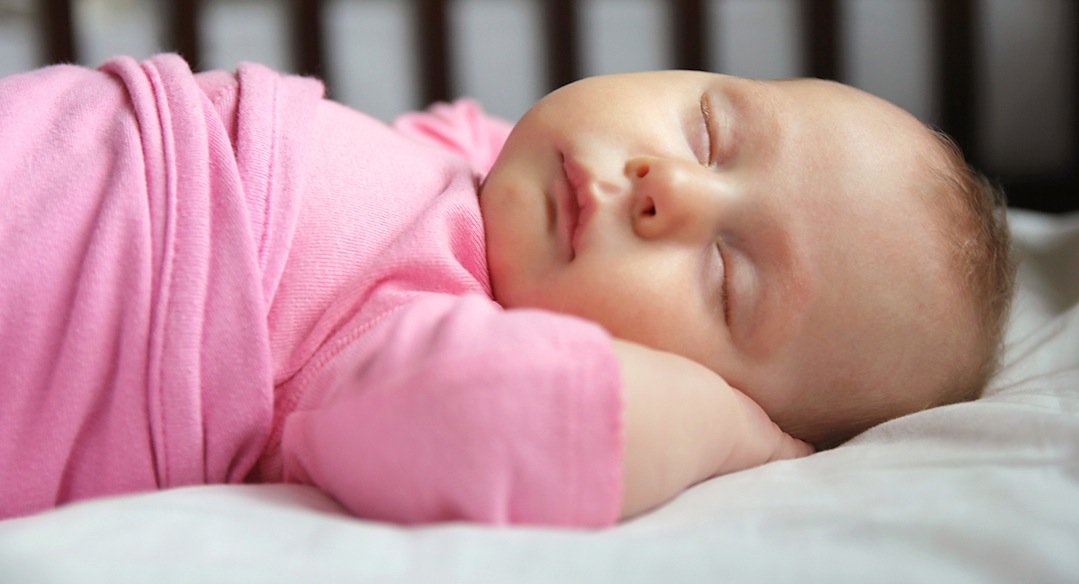Sweet Newborn Baby Girl Asleep in Crib