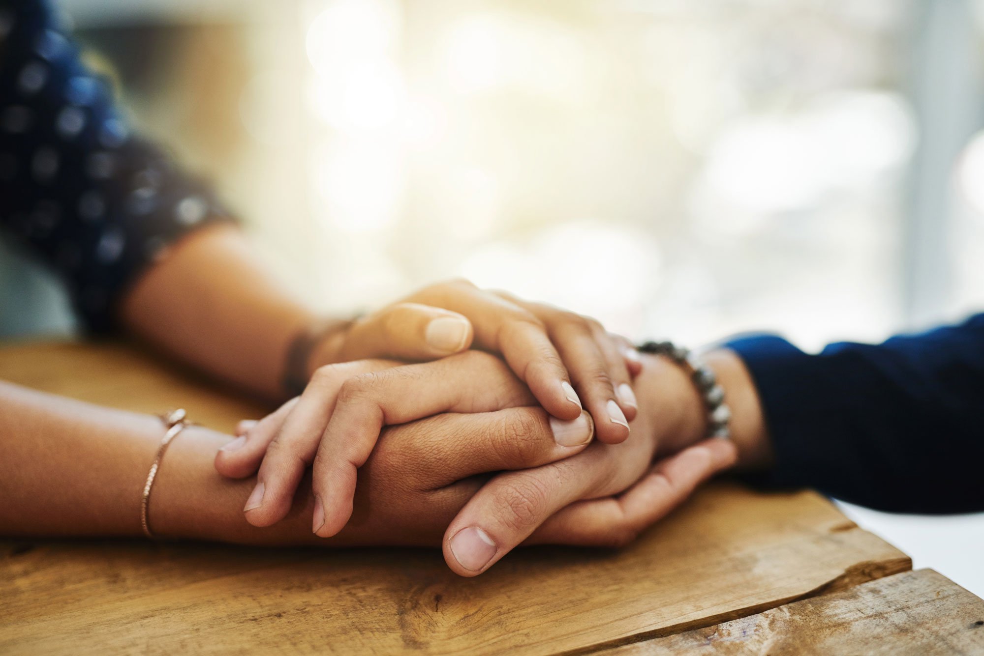 Closeup of two people holding hands