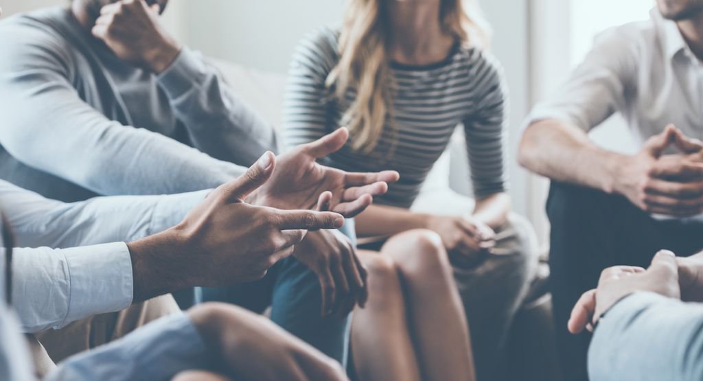 Hands in the center of a group of people