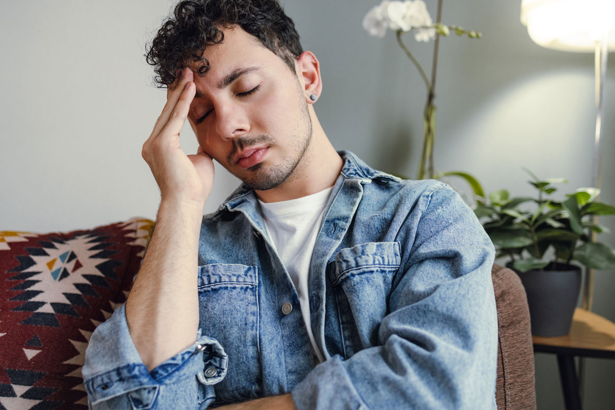 Young man holding his hand to his head