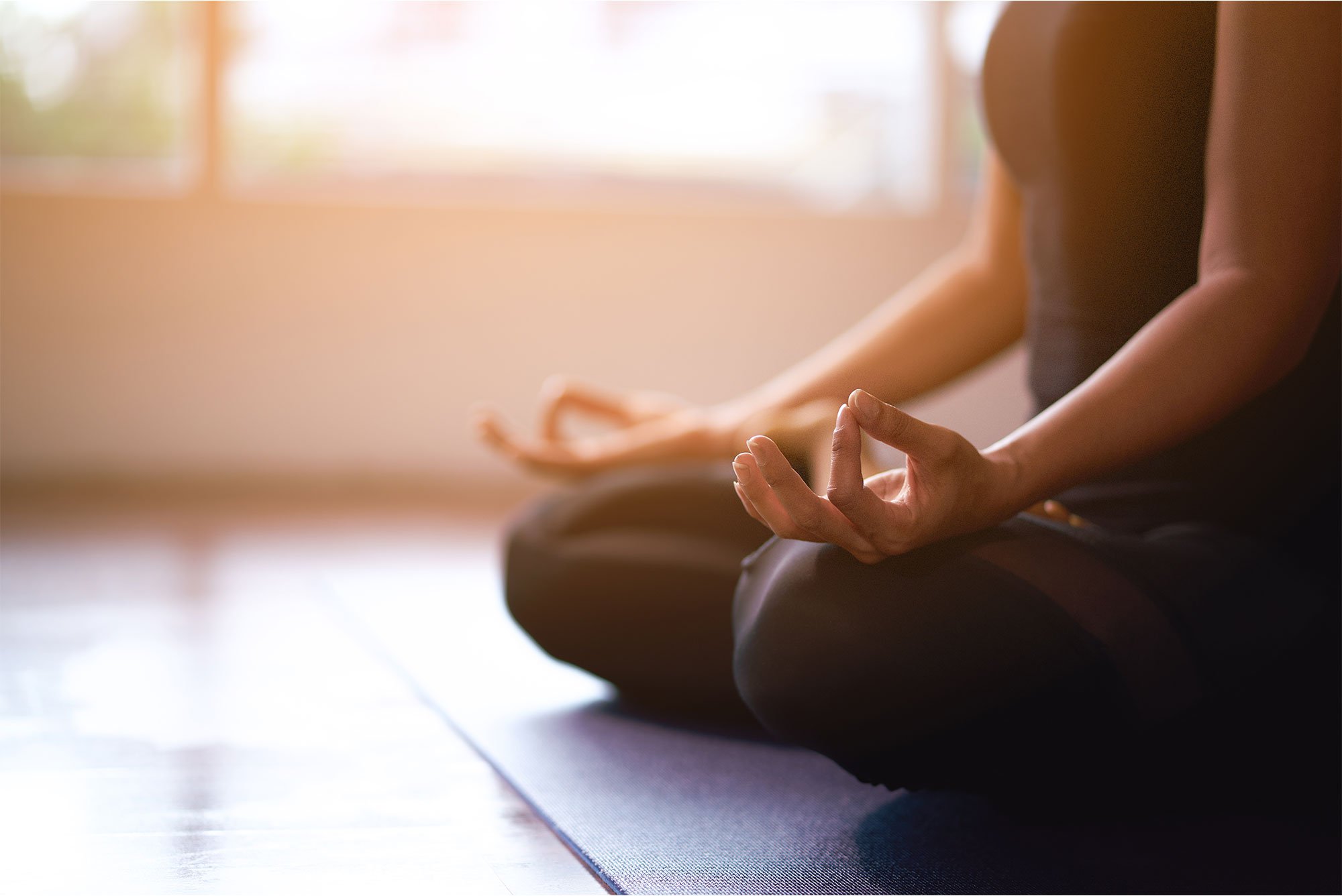 Woman sitting on floor with legs crossed meditating