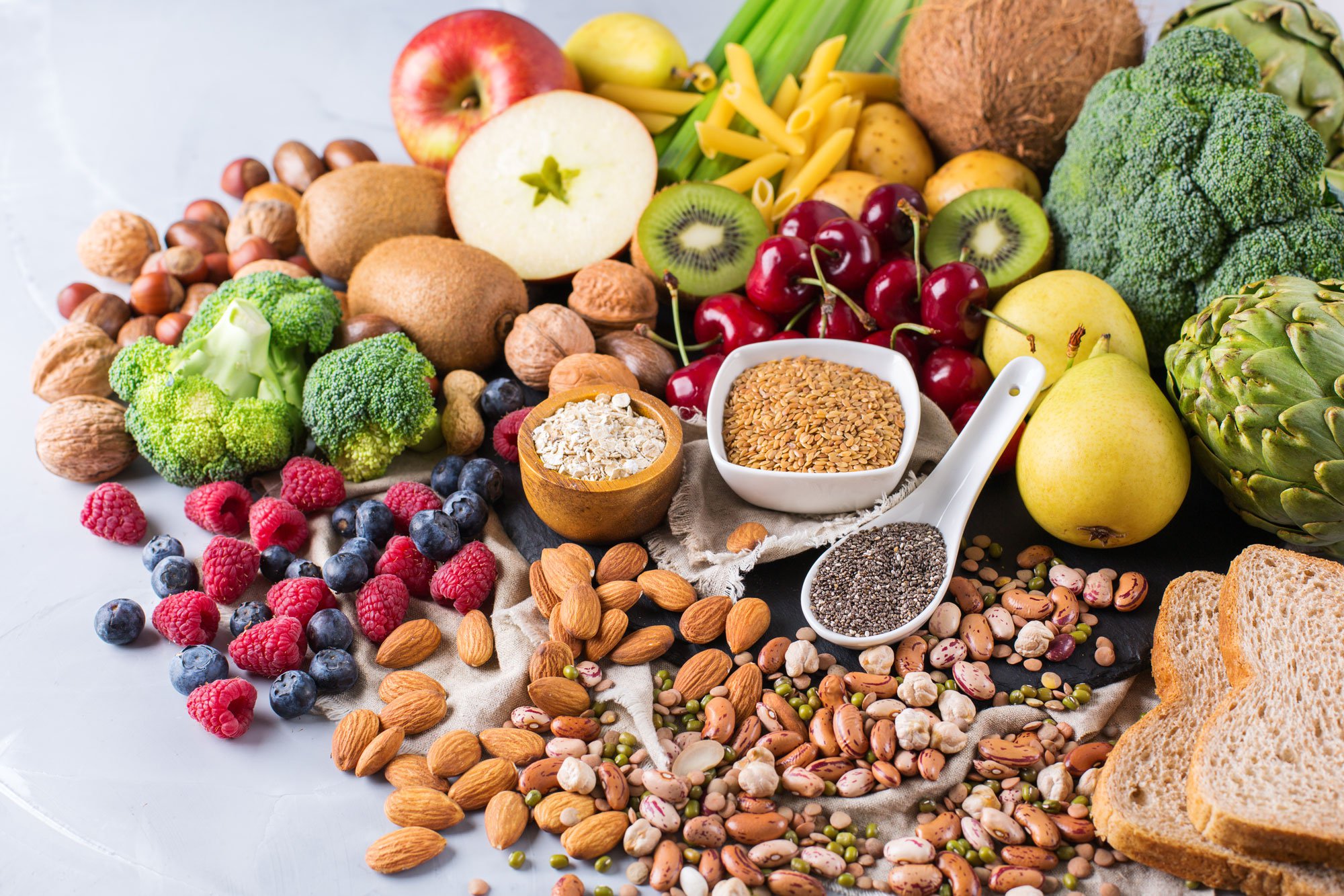 Heart-healthy foods including nuts, fruits, veggies, seeds, beans, and whole grains