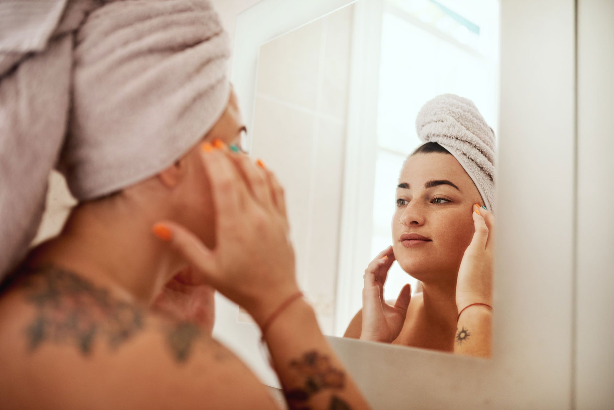 Women inspecting face in the mirror