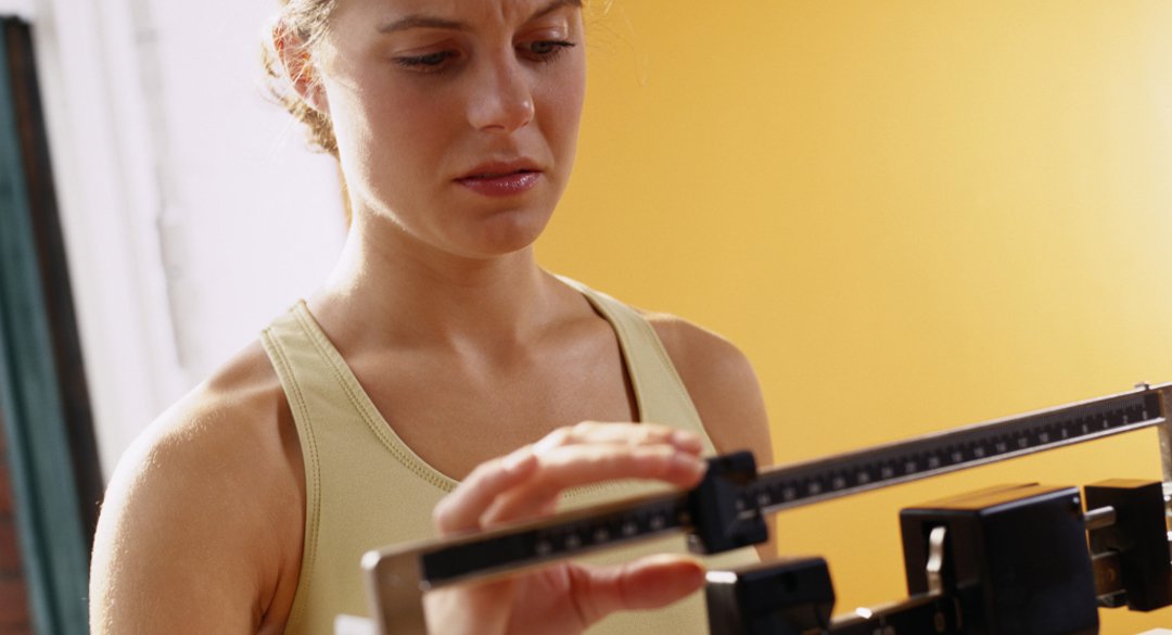 Woman on a scale weighing herself