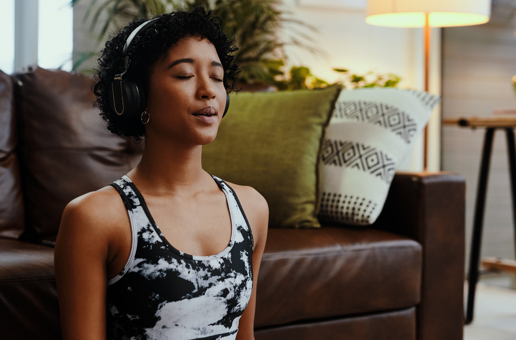 Young woman practicing deep breathing while listening to music