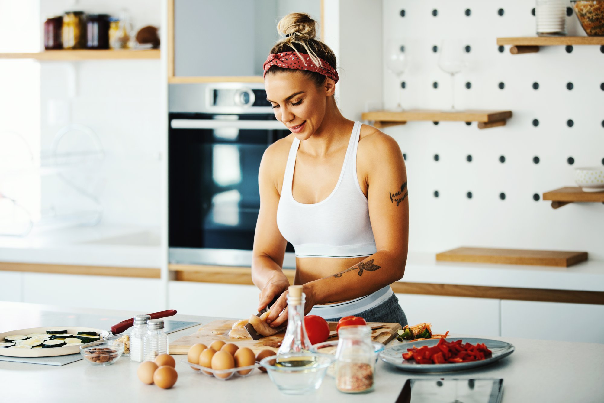 Woman chopping chicken at kitchen counter