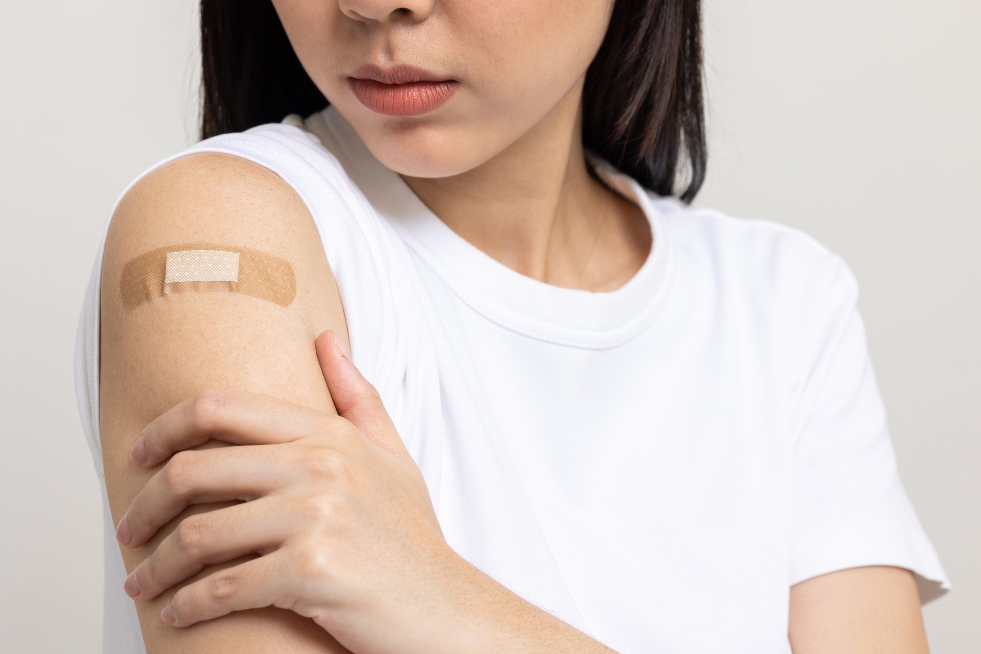 Close up of woman's arm with bandage over it.