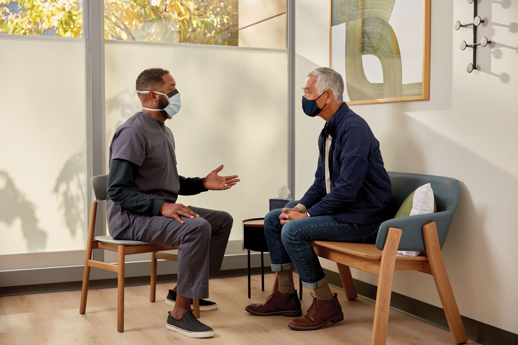 Older man sitting and talking with a One Medical provider