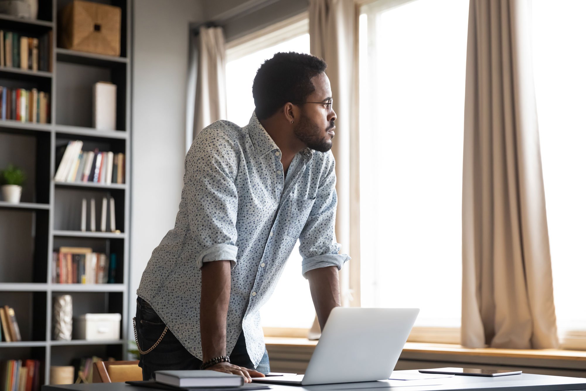 man looking away from laptop