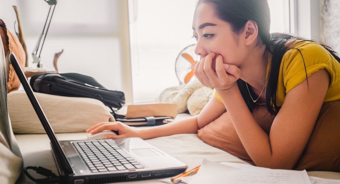 Woman laying down working on a laptop