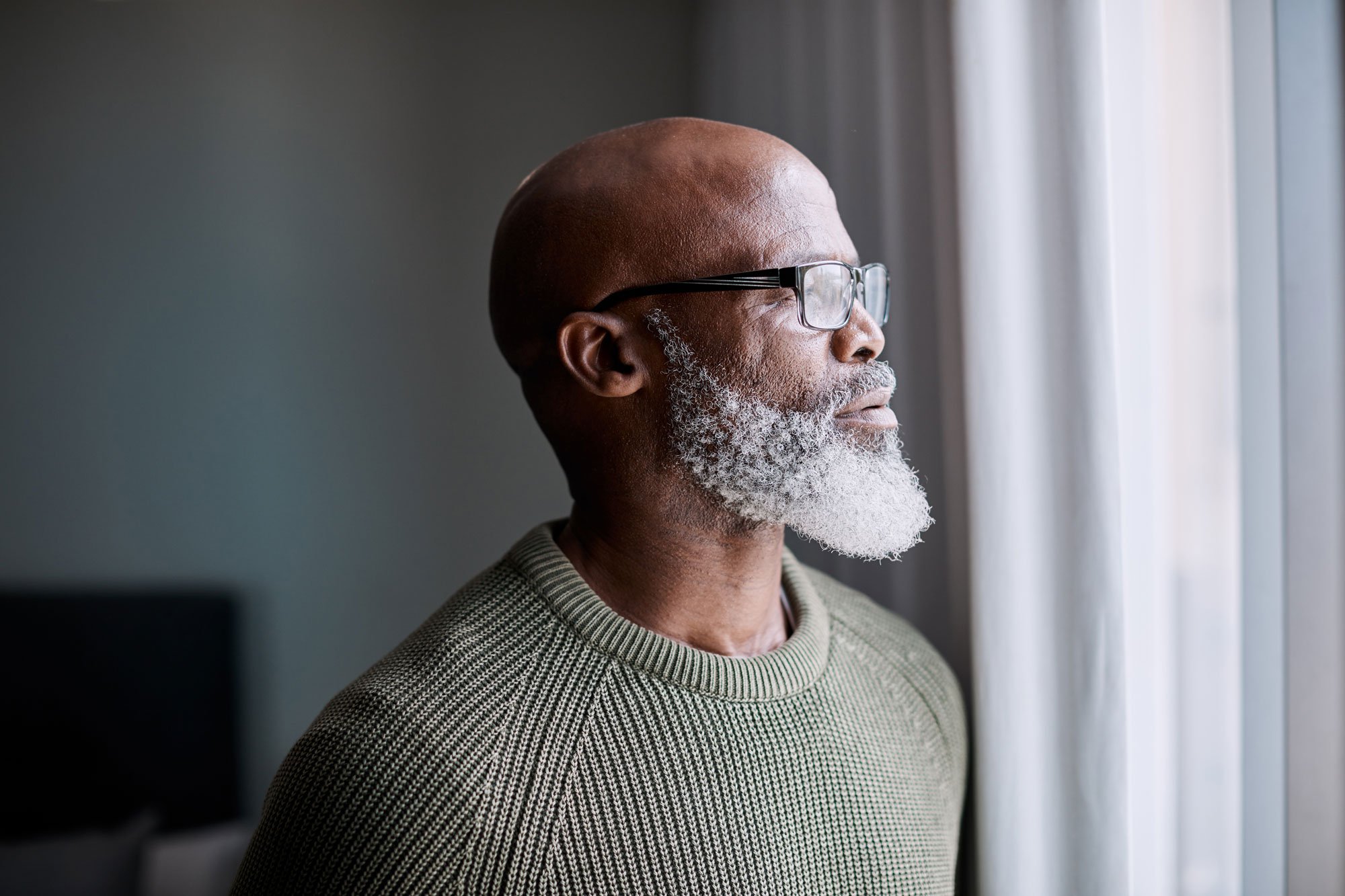 older man looking out window