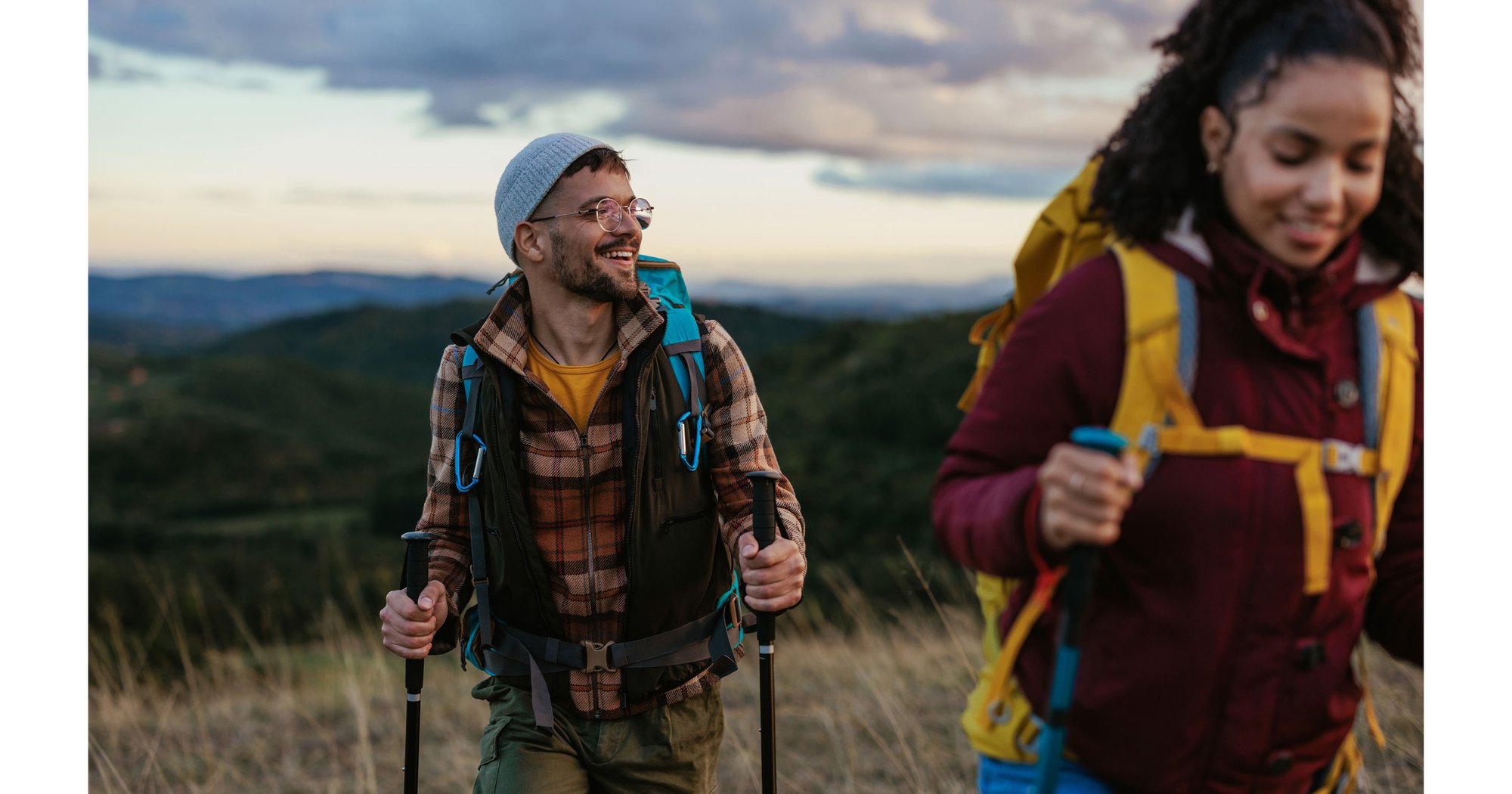 Happy couple hiking up hill