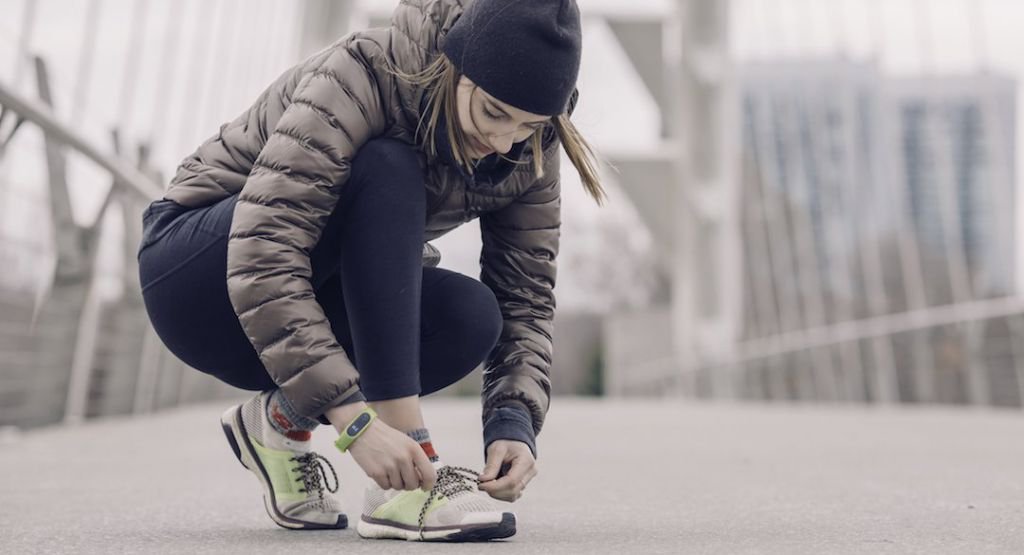 Woman outdoors tying her shoe