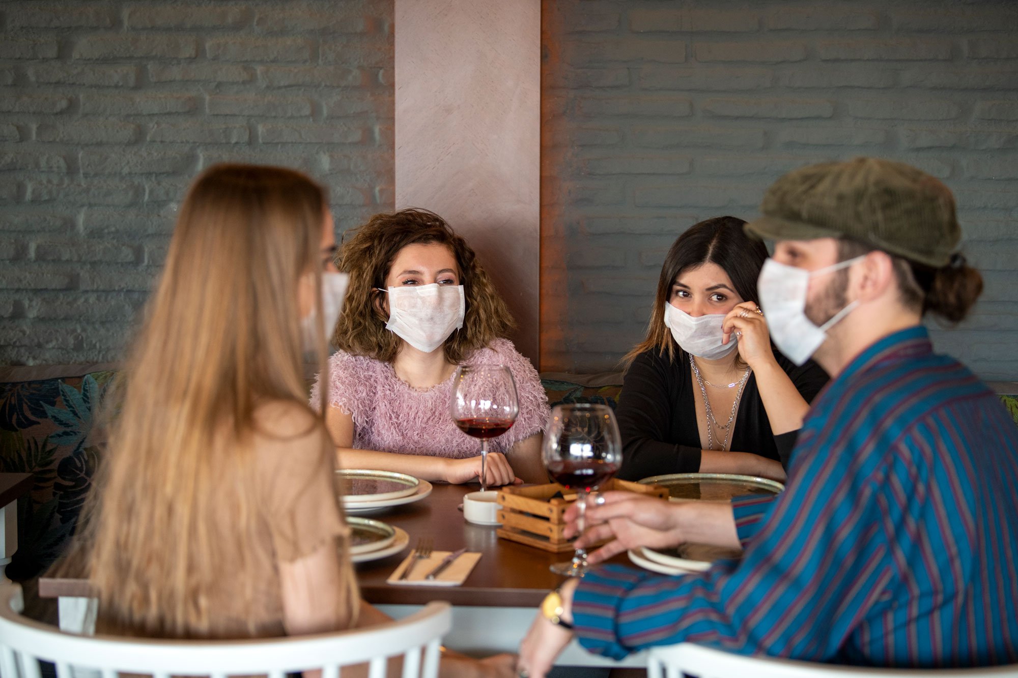 people at restaurant wearing masks