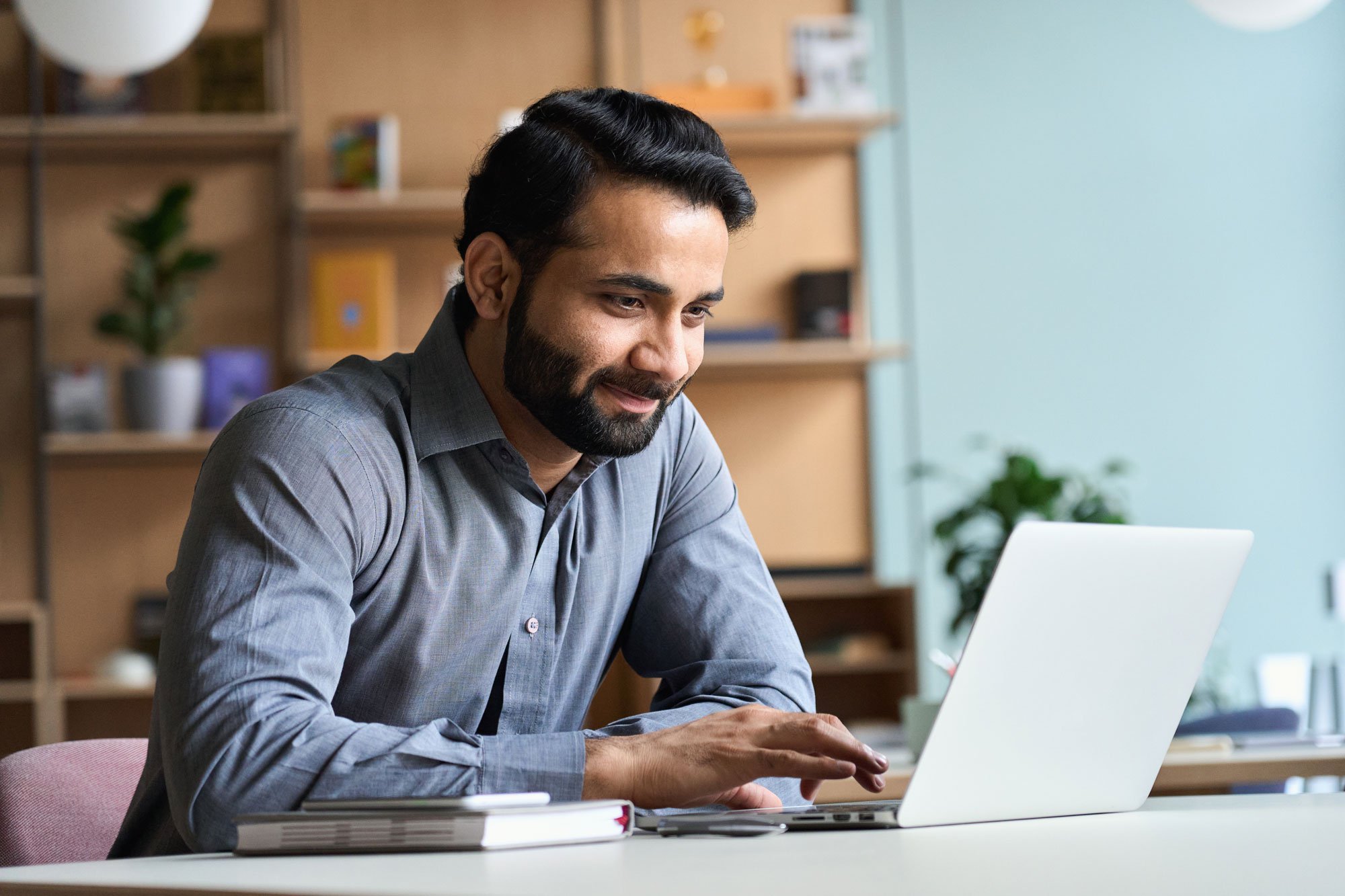 Man sitting at desk and working on a laptop