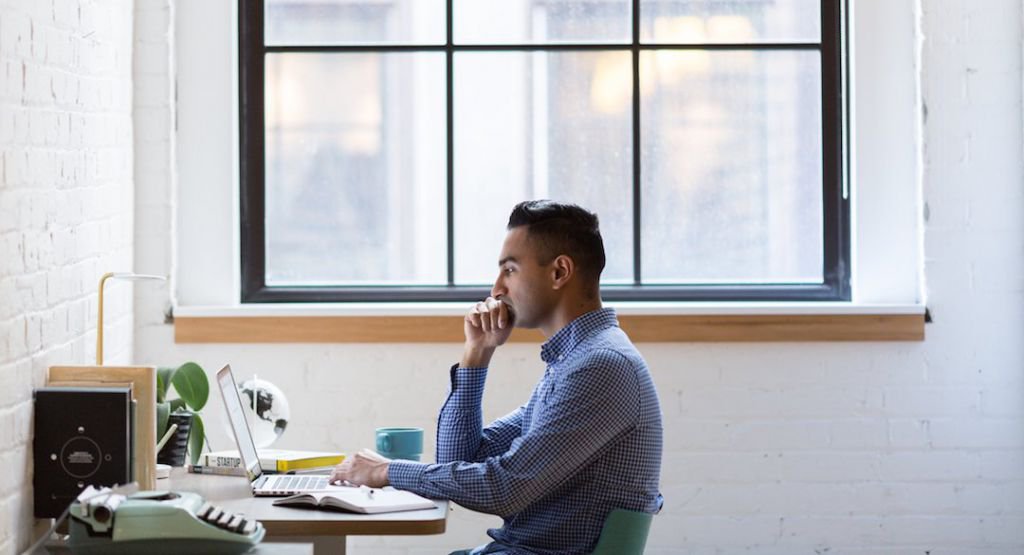 Man sitting and working on his computer at a desk