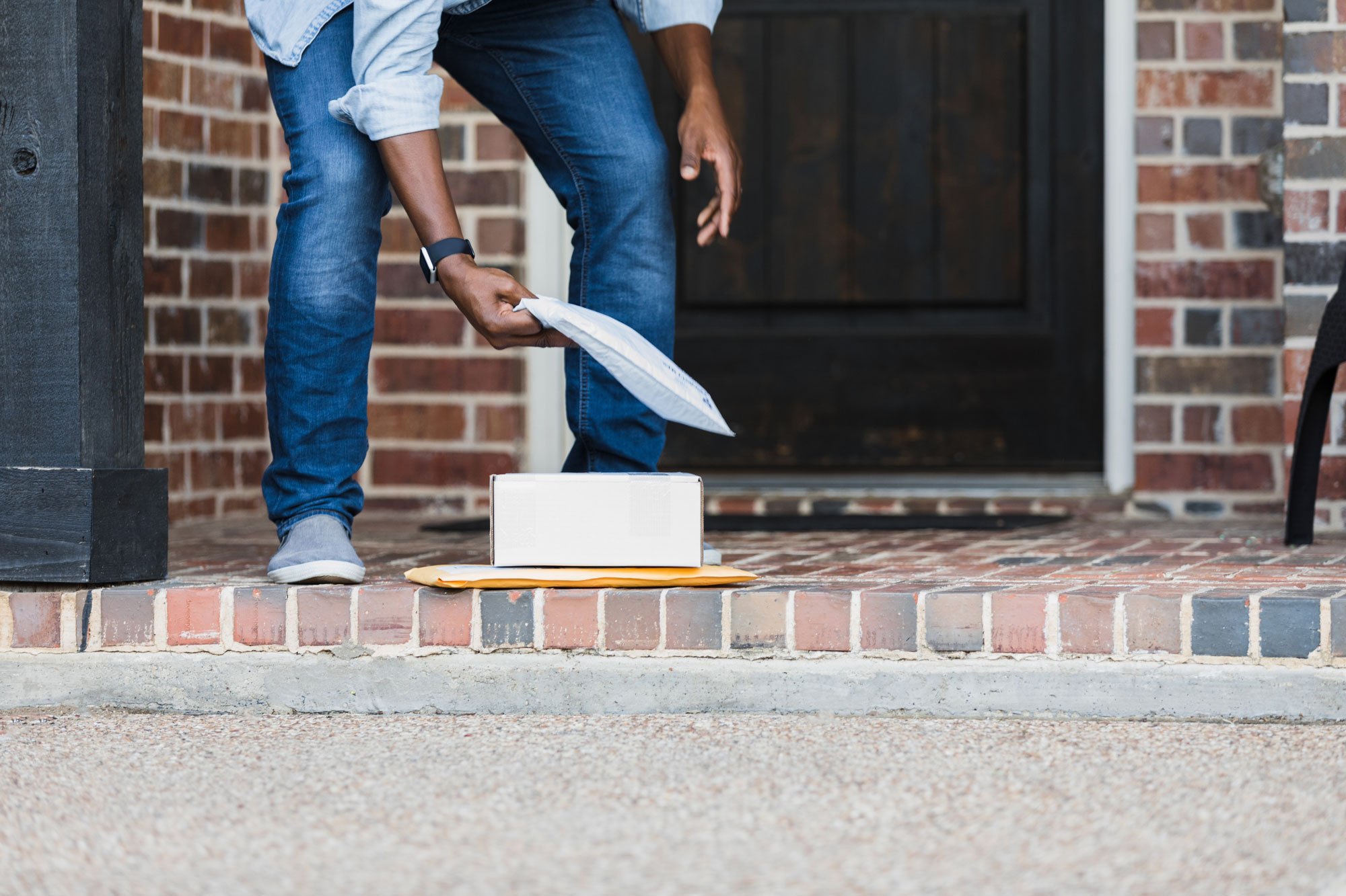 Man picking up package on doorstep