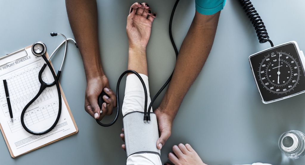 Man taking blood pressure of person's arm