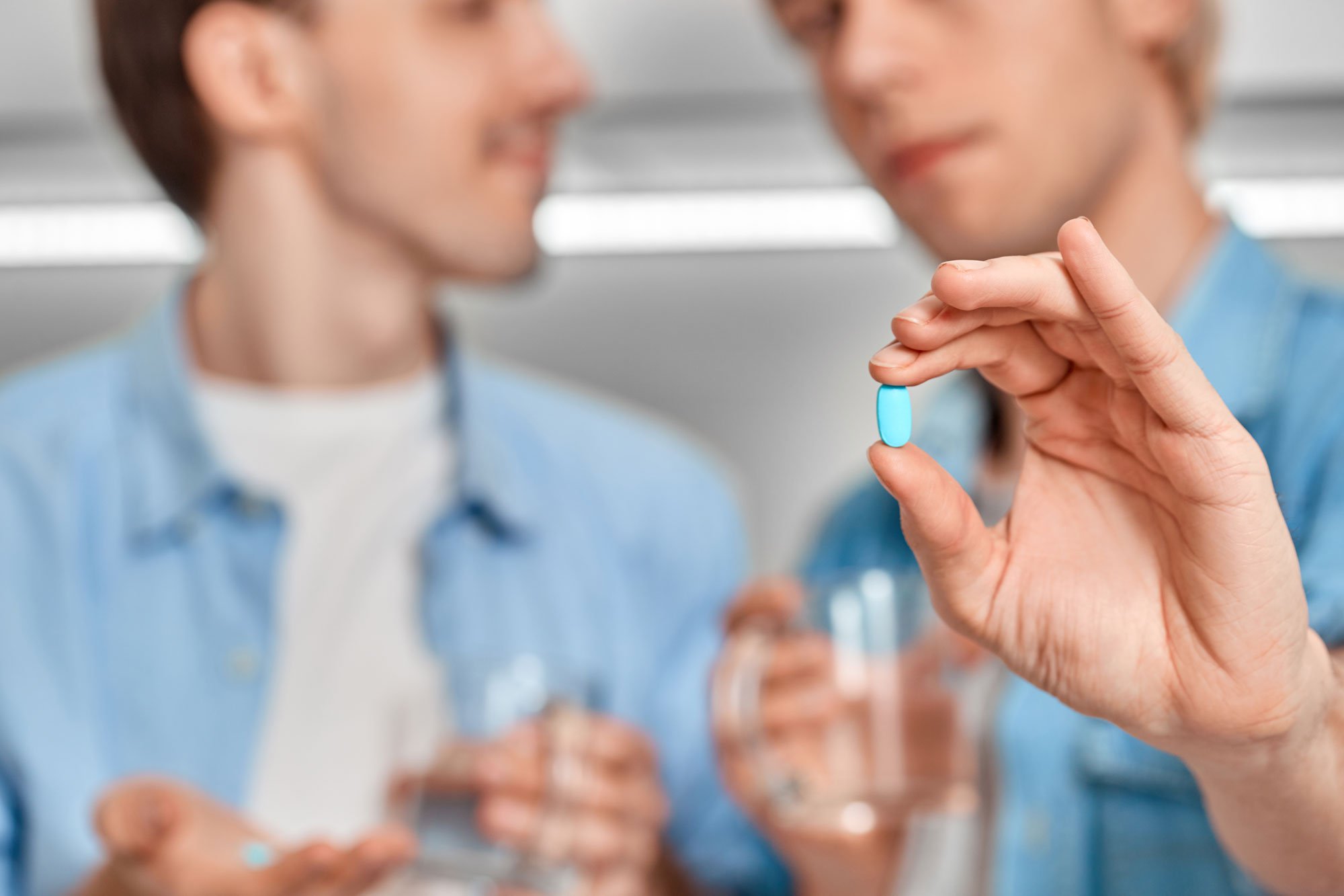 Two men holding prEP pills