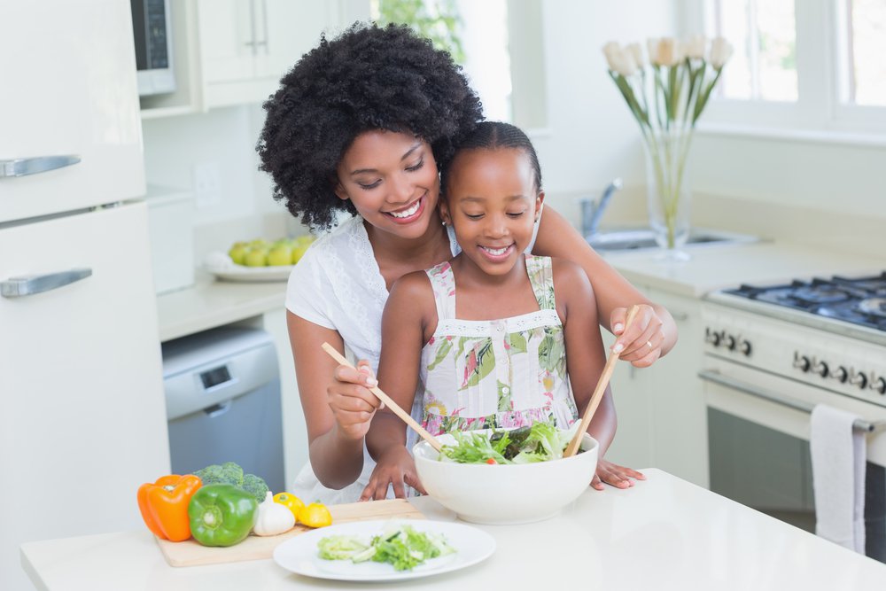 Woman and daughter making salad