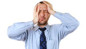 Man with tie holding his head because of headache