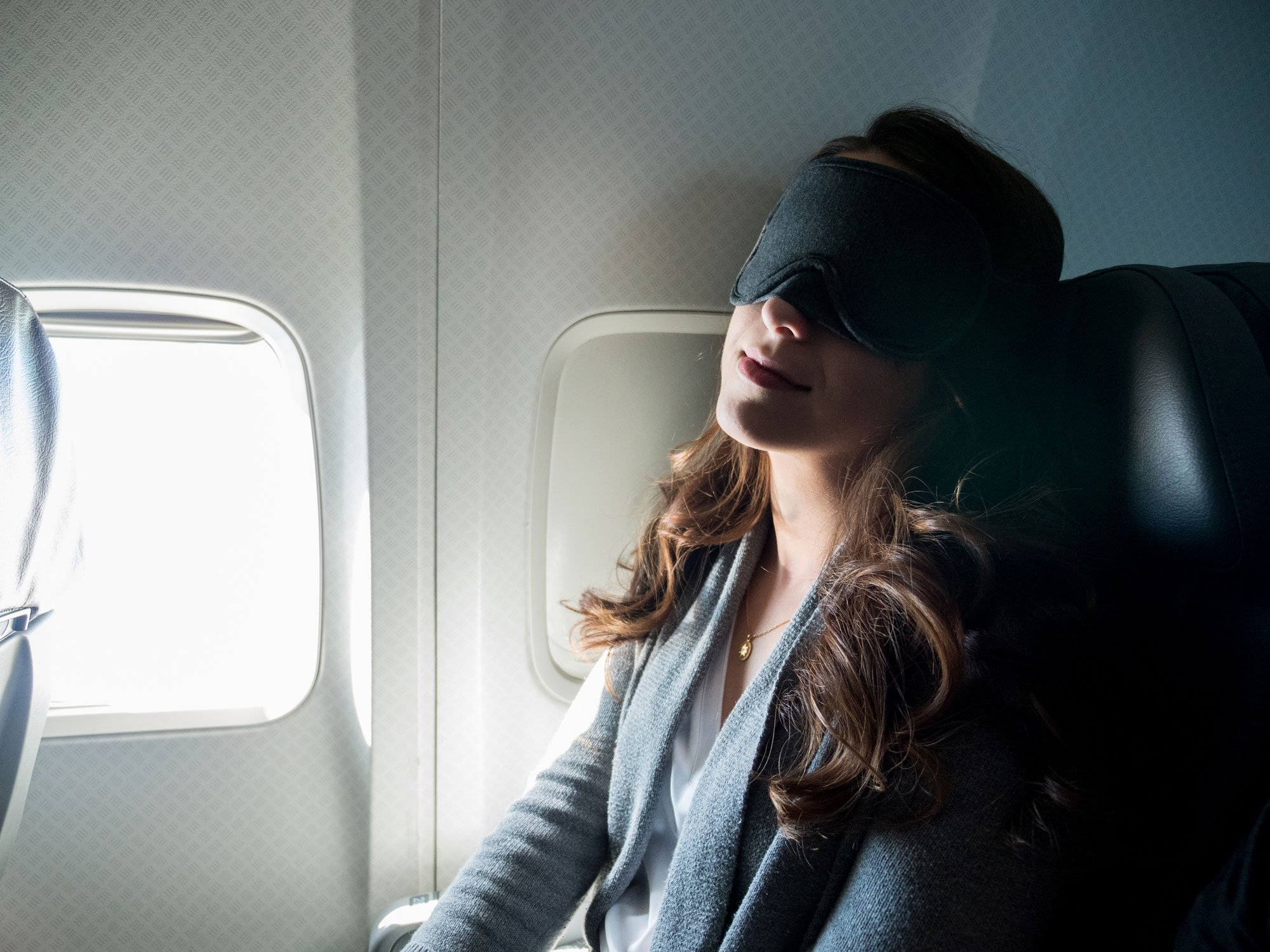 Woman sleeping on plane with eye mask on