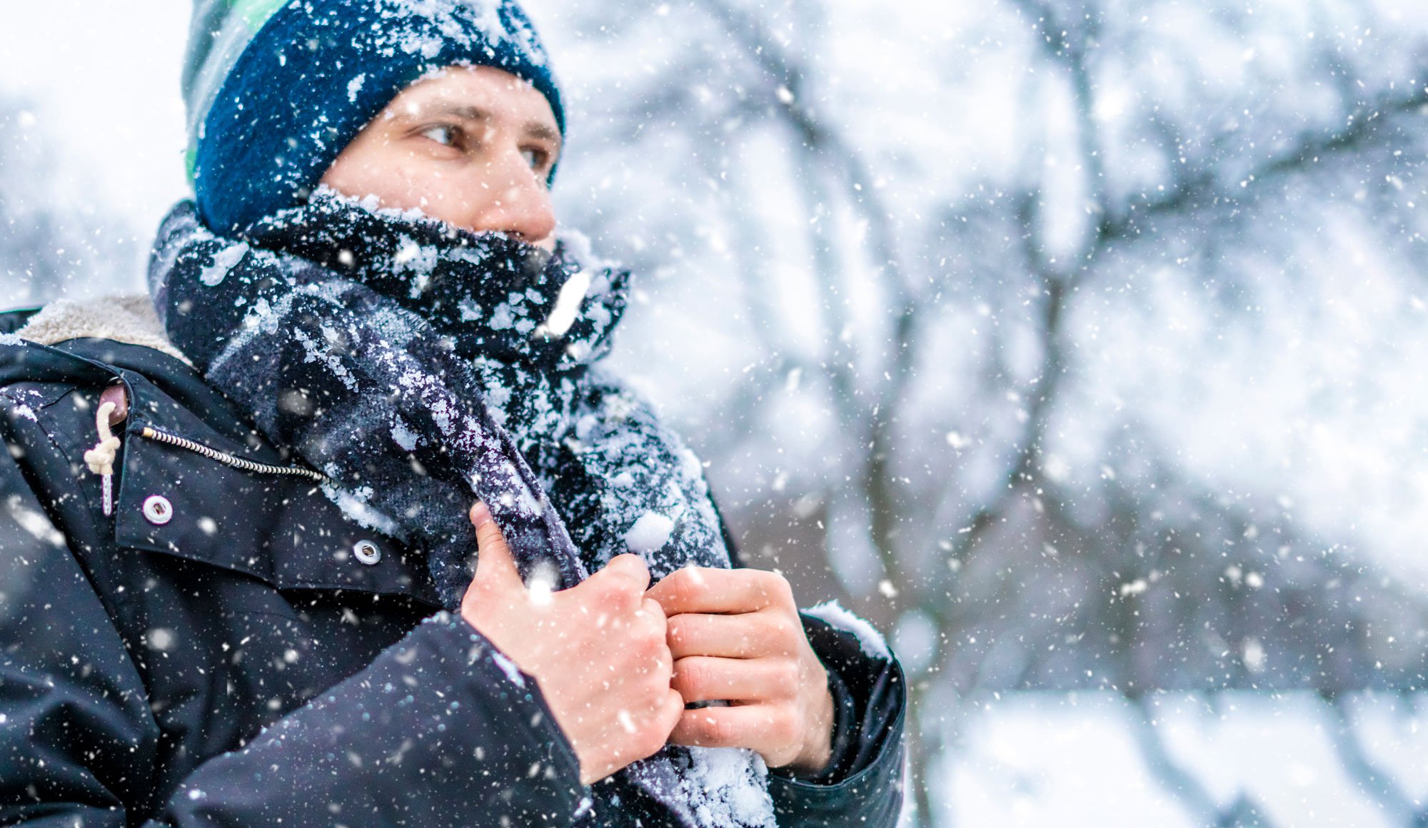 Man wearing scarf outside covered in snow