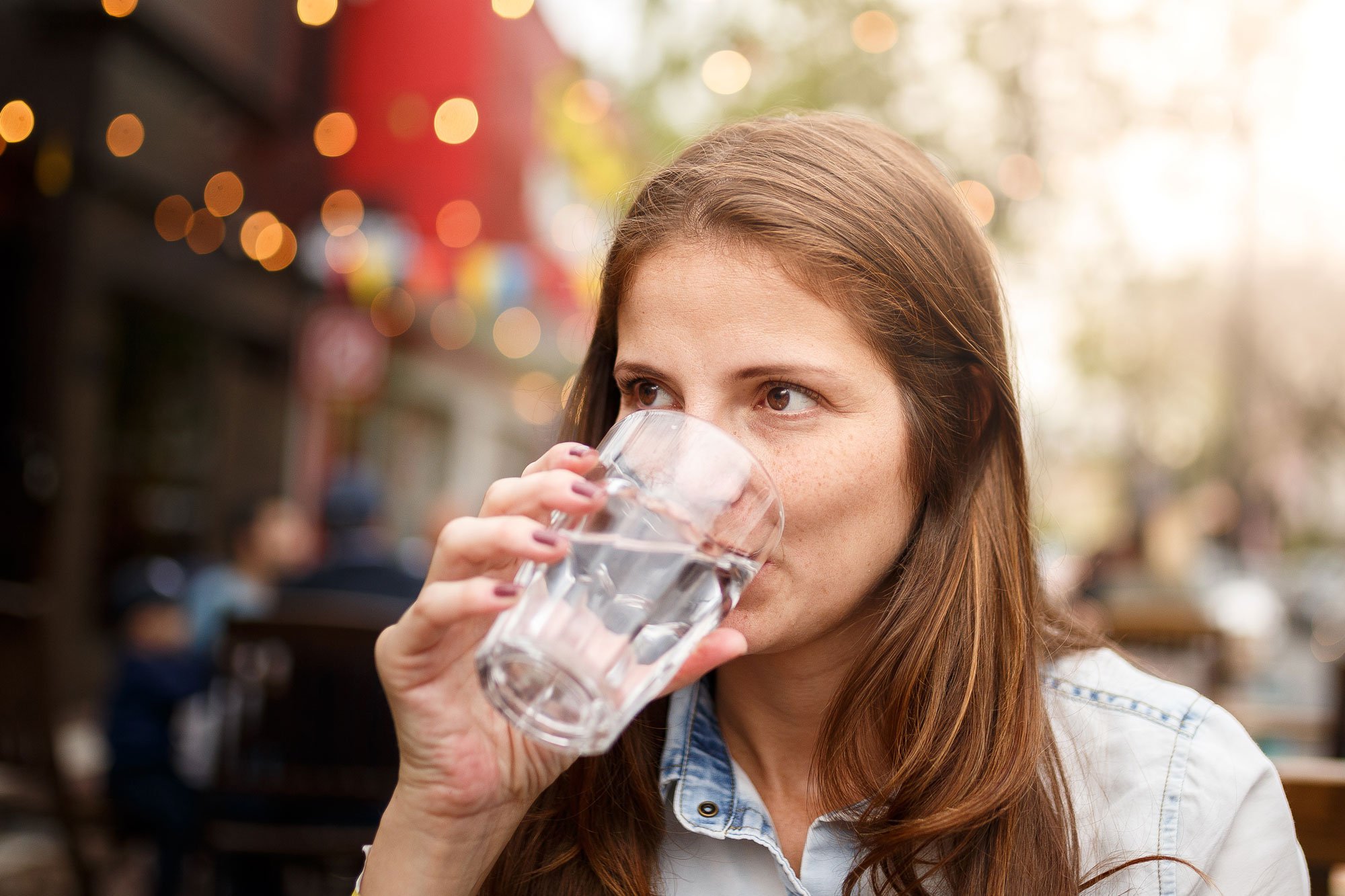 Women sitting outside at restaurant drinking water