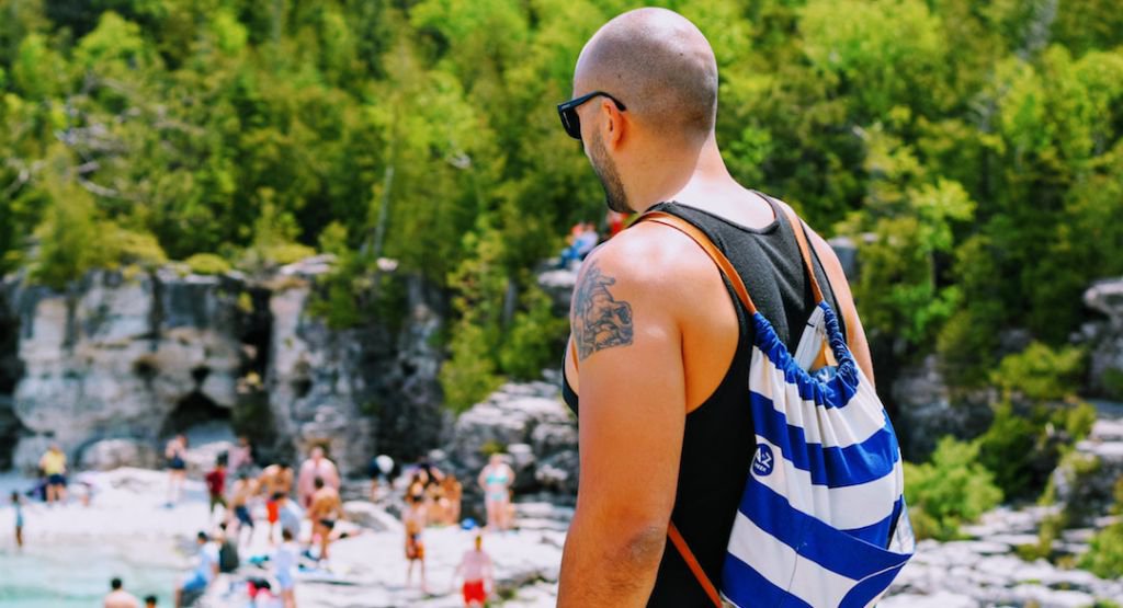 Man with backpack in front of beach