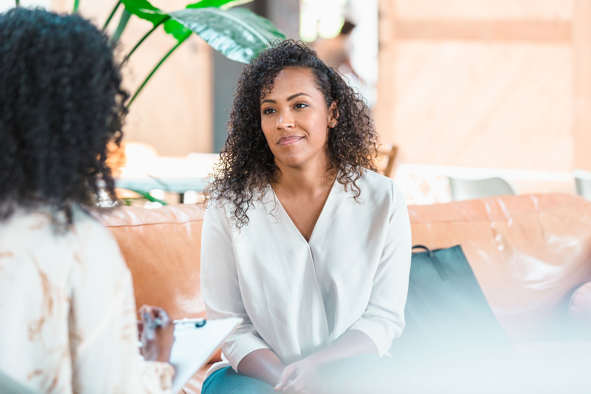 Woman sitting on couch talking to provider