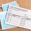 COVID-19 vaccination record card next to a medical procedure mask.