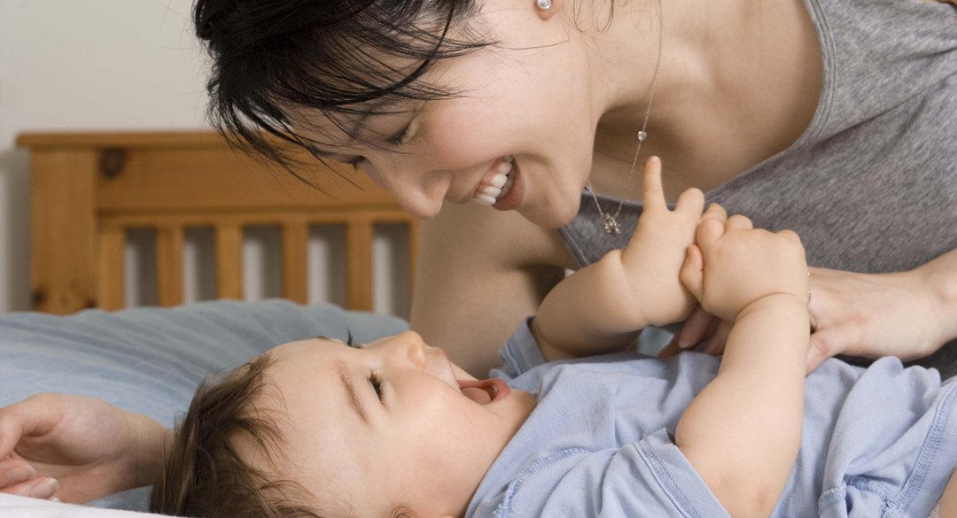 Woman looking into the eyes of her child and smiling