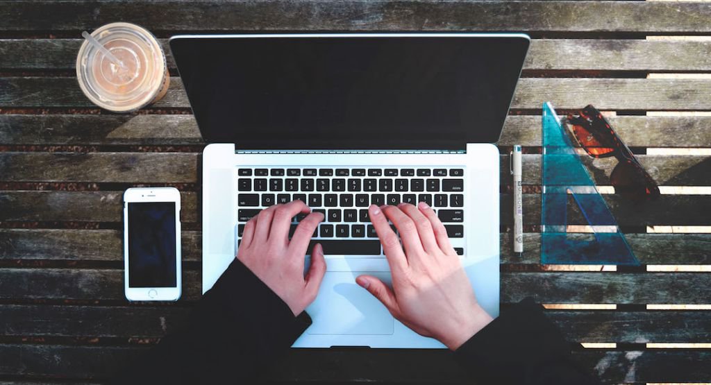 Overhead view of a person typing on a laptop